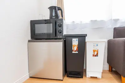 a microwave and a refrigerator with a tv on top of it at \u83ca\u5ddd\u99c5\u5f92\u6b69\u516d\u5206 Zaito Kiku House in Tokyo