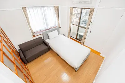 a small bedroom with a bed and a couch at \u83ca\u5ddd\u99c5\u5f92\u6b69\u516d\u5206 Zaito Kiku House in Tokyo