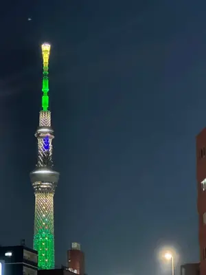 a tall tower lit up in green and blue at \u6d45\u8349 \u30b9\u30ab\u30a4\u30c4\u30ea\u30fc\u570f10\u5206 \u4ea4\u901a\u81f3\u4fbf \u6d45\u8349\u5bfa\u89b3\u5149 \u53cc\u9b5a\u306e\u5bbf \u6771\u5411\u5cf65 in Tokyo