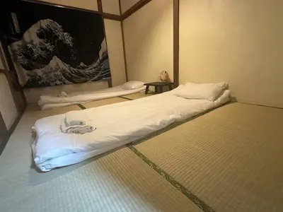 a large bed in a room with a painting at \u6d45\u8349 \u30b9\u30ab\u30a4\u30c4\u30ea\u30fc\u570f10\u5206 \u4ea4\u901a\u81f3\u4fbf \u6d45\u8349\u5bfa\u89b3\u5149 \u53cc\u9b5a\u306e\u5bbf \u6771\u5411\u5cf65 in Tokyo