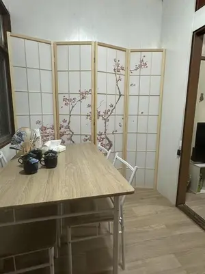 a dining room with a wooden table and flowers on the wall at \u6d45\u8349 \u30b9\u30ab\u30a4\u30c4\u30ea\u30fc\u570f10\u5206 \u4ea4\u901a\u81f3\u4fbf \u6d45\u8349\u5bfa\u89b3\u5149 \u53cc\u9b5a\u306e\u5bbf \u6771\u5411\u5cf65 in Tokyo