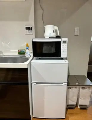 a microwave sitting on top of a refrigerator in a kitchen at \u65e9\u7a3b\u7530\u5927\u5b66\u5f92\u6b653\u5206 \u76f4\u8fbe\u65e5\u672c\u6865\u6c60\u888b\u65b0\u5bbf\u4e0a\u91ce \u5357\u5317\u901a\u900f\u6709\u7535\u68af \u5468\u8fb9\u751f\u6d3b\u4fbf\u5229 in Tokyo