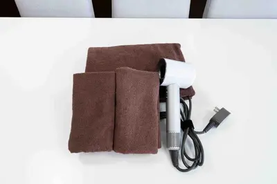 a blow dryer and towels on a table at SUA HOTEL Shinjuku Yochomachi in Tokyo