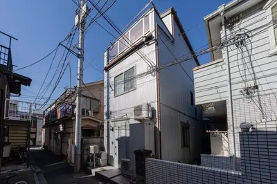 an alley with a white building and power lines at SUA HOTEL Shinjuku Yochomachi in Tokyo
