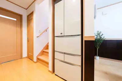 a kitchen with white cabinets and a staircase at SUA HOTEL Shinjuku Yochomachi in Tokyo