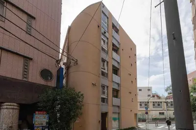 a tall building with a circle on the side of it at SUA HOTEL Shinjuku in Tokyo