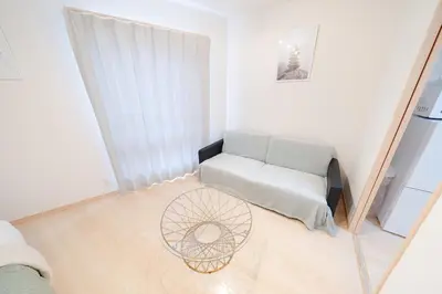 a living room with a couch and a mirror at SUA HOTEL Shinjuku in Tokyo