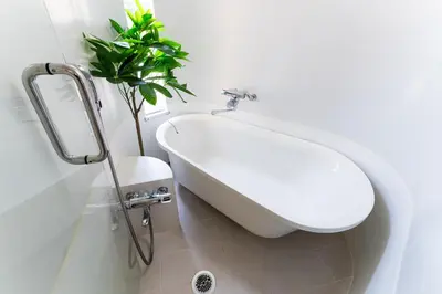 a bathroom with a white tub and a potted plant at SUA HOTEL Shinjuku in Tokyo