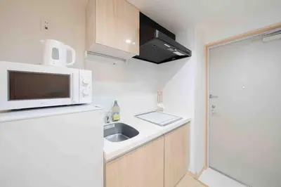 a small kitchen with a sink and a microwave at SUA HOTEL Shinjuku in Tokyo
