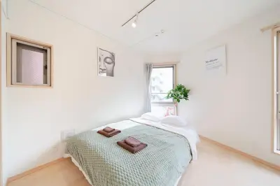 a white bedroom with a bed and a window at SUA HOTEL Shinjuku in Tokyo