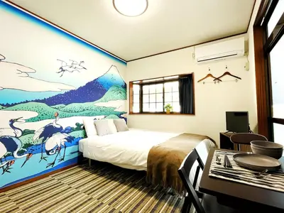a bedroom with a bed and a painting on the wall at KYM Heights in Tokyo