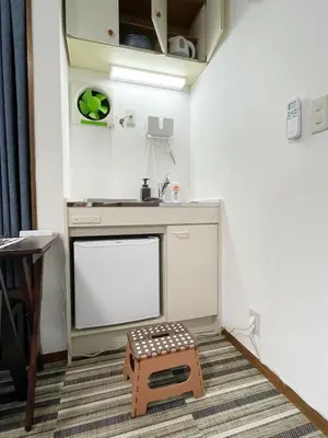 a living room with a tv and a stool at KYM Heights in Tokyo