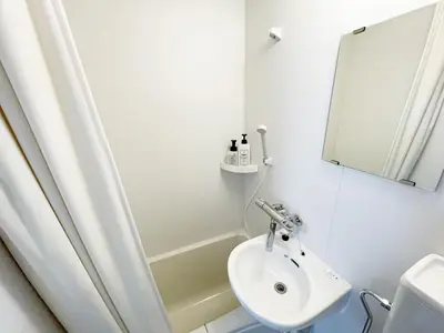 a white bathroom with a sink and a shower at KYM Heights in Tokyo