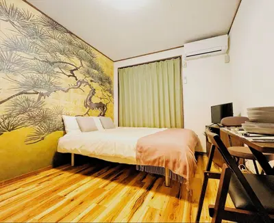 a bedroom with a bed with a painting on the wall at KYM Heights in Tokyo