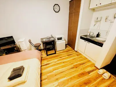 a living room with a bed and a kitchen at KYM Heights in Tokyo