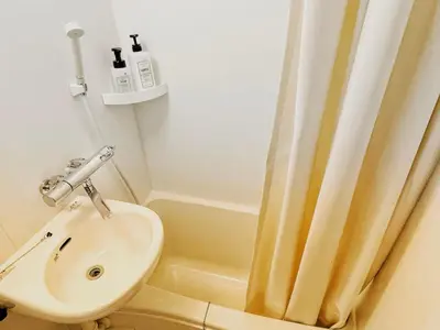 a bathroom with a sink and a shower curtain at KYM Heights in Tokyo