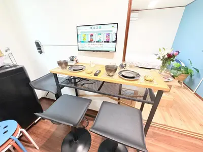 a table with chairs and a television in a room at \u6d45\u8349\u307e\u306d\u304d\u5eb5 25\u5e74\u30d5\u30eb\u30ea\u30ce\u30d9 \u5b8c\u5168\u8cb8\u5207 \u6d45\u8349\u99c5\u5f92\u6b6915\u5206 2\u30d9\u30c3\u30c9\u30eb\u30fc\u30e0 6\u4eba 38\u5e73\u7c73 \u4e2d\u9577\u671f\u6ede\u5728\u5927\u6b53\u8fce in Tokyo