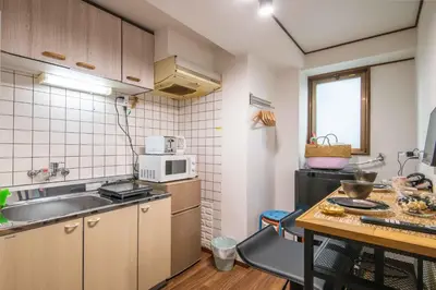 a small kitchen with a sink and a microwave at \u6d45\u8349\u307e\u306d\u304d\u5eb5 25\u5e74\u30d5\u30eb\u30ea\u30ce\u30d9 \u5b8c\u5168\u8cb8\u5207 \u6d45\u8349\u99c5\u5f92\u6b6915\u5206 2\u30d9\u30c3\u30c9\u30eb\u30fc\u30e0 6\u4eba 38\u5e73\u7c73 \u4e2d\u9577\u671f\u6ede\u5728\u5927\u6b53\u8fce in Tokyo