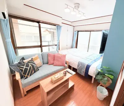 a small bedroom with a bed and a couch at \u6d45\u8349\u307e\u306d\u304d\u5eb5 25\u5e74\u30d5\u30eb\u30ea\u30ce\u30d9 \u5b8c\u5168\u8cb8\u5207 \u6d45\u8349\u99c5\u5f92\u6b6915\u5206 2\u30d9\u30c3\u30c9\u30eb\u30fc\u30e0 6\u4eba 38\u5e73\u7c73 \u4e2d\u9577\u671f\u6ede\u5728\u5927\u6b53\u8fce in Tokyo