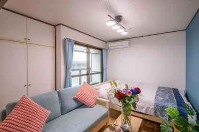 a living room with a couch and a vase of flowers at \u6d45\u8349\u307e\u306d\u304d\u5eb5 25\u5e74\u30d5\u30eb\u30ea\u30ce\u30d9 \u5b8c\u5168\u8cb8\u5207 \u6d45\u8349\u99c5\u5f92\u6b6915\u5206 2\u30d9\u30c3\u30c9\u30eb\u30fc\u30e0 6\u4eba 38\u5e73\u7c73 \u4e2d\u9577\u671f\u6ede\u5728\u5927\u6b53\u8fce in Tokyo