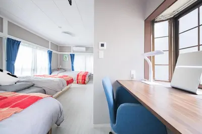 a bedroom with two beds and a desk with a blue chair at JJ HOUSE Omori Heiwajima - Near Shinagawa Haneda Airport - Japanese Style Room - Floor Heating System in Tokyo
