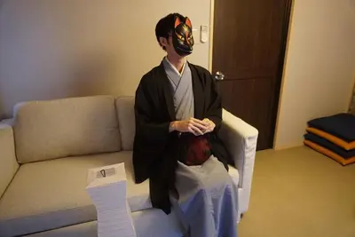 a man wearing a mask sitting on a couch at WA NO YADO-Asakusa Retreat 10 min walk from Asakusa Designer curated stylish room 4 in Tokyo