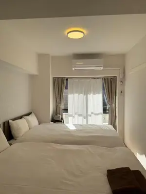 a bedroom with two beds and a window at The Waseda Villa \u30f4\u30a3\u30e9\u65e9\u7a32\u7530 in Tokyo