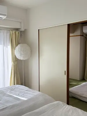 a bedroom with a sliding glass door to a bed at The Waseda Villa \u30f4\u30a3\u30e9\u65e9\u7a32\u7530 in Tokyo