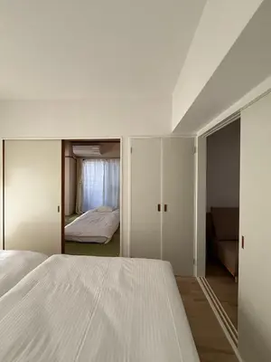 a bedroom with a white bed and a room with a couch at The Waseda Villa \u30f4\u30a3\u30e9\u65e9\u7a32\u7530 in Tokyo