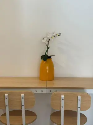 an orange vase with white flowers on a wooden shelf at The Waseda Villa \u30f4\u30a3\u30e9\u65e9\u7a32\u7530 in Tokyo