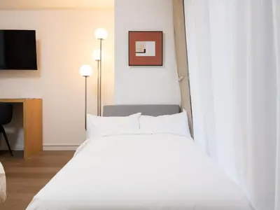 a bed with white sheets and pillows in a room at RARE-EBISU BREEZE Apartment in Tokyo