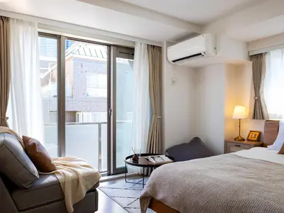 a hotel room with a bed and a chair and a window at RARE-EBISU BREEZE Apartment in Tokyo
