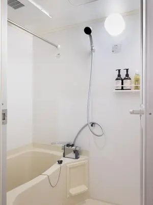 a shower in a white bathroom with a bathtub at RARE-EBISU BREEZE Apartment in Tokyo
