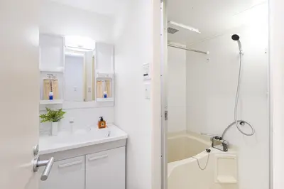 a white bathroom with a shower and a sink at RARE-EBISU BREEZE Apartment in Tokyo