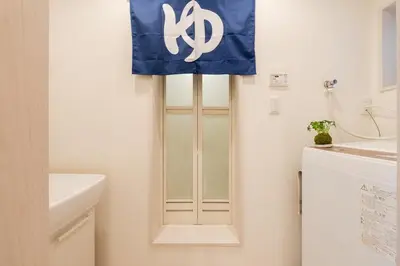 a bathroom with a white cabinet with a blue curtain at Cheerful Kanegafuchi in Tokyo