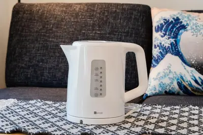 a white electric kettle sitting on a couch at Cheerful Kanegafuchi in Tokyo