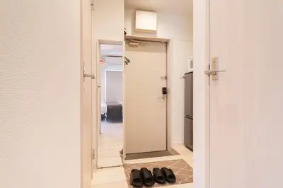 a mirror in a hallway with black shoes at Cheerful Kanegafuchi in Tokyo