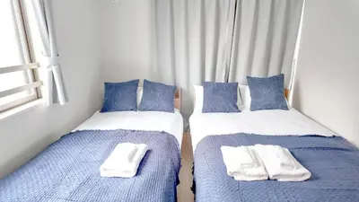 two beds in a room with blue and white at 9Stay\u4e0a\u91ce\u5165\u8c37 in Tokyo