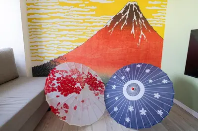 two umbrellas sitting on the floor in front of a painting at Cheerful Takadanobaba in Tokyo