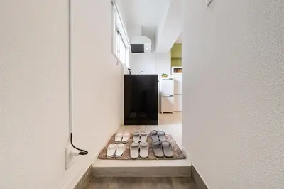 a row of shoes sitting on a shelf in a room at Cheerful Takadanobaba in Tokyo
