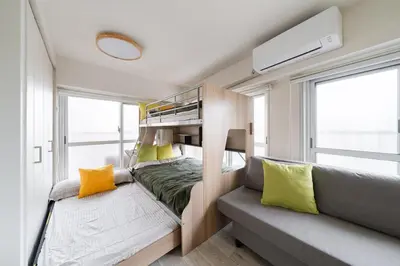 a small bedroom with a bunk bed and a couch at Cheerful Takadanobaba in Tokyo