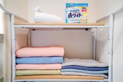 a shelf with towels and a box of milk at 202Room, 5 mins walk from JR Kinshicho North Exit!Near Asakusa & Sky Tree!! The house is on the 2th floor with an elevator, convenient transportation There is a balcony and the room is soundproofed in Tokyo
