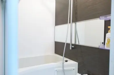 a bathroom with a shower with a white tub at Tierra Mukojima in Tokyo