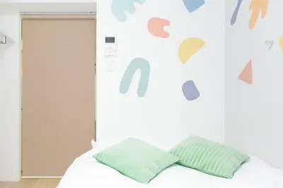 a bedroom with a bed with green pillows at Tierra Mukojima in Tokyo