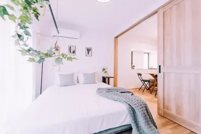 a bedroom with a white bed and a table at Showa Bloom Shinjuku 3 in Tokyo