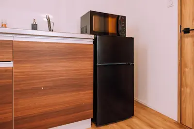 a microwave sitting on top of a refrigerator in a kitchen at Showa Bloom Shinjuku 3 in Tokyo