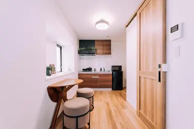 a kitchen with a table and stools in a room at Showa Bloom Shinjuku 3 in Tokyo