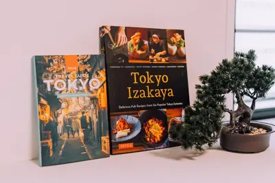 three books sitting on a table next to a plant at Showa Bloom Shinjuku 3 in Tokyo