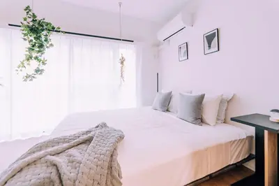 a white bedroom with a large bed and a window at Showa Bloom Shinjuku 3 in Tokyo