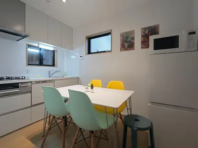 a kitchen with a white table and yellow chairs at \u51dc\u68ee Rinmori - \u6700\u59277\u540d\u5bbf\u6cca\u53ef - \u6771\u4eac\u30b9\u30ab\u30a4\u30c4\u30ea\u30fc\u307e\u3067\u5f92\u6b69\u570f\u5185 in Tokyo